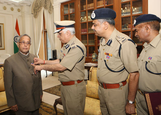 The Director of the Delhi Fire Service, Shri A.K. Sharma with others pinning a flag on the President of India, Shri Pranab Mukherjee at Rashtrapati Bhavan in New Delhi on April 15, 2013 on the occasion of Fire Service Week.