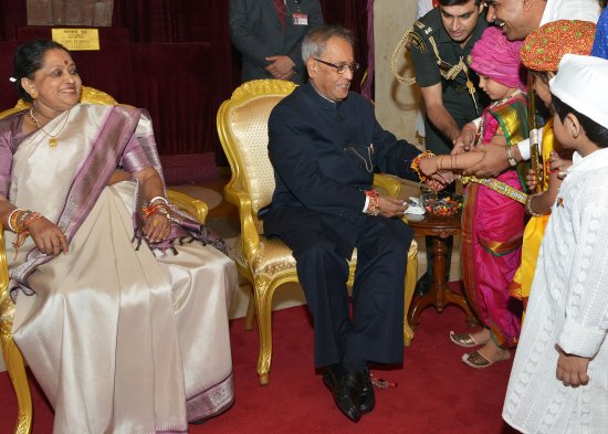 A child tying a Rakhi on the wrist of the President of India, Shri Pranab Mukherjee at Rashtrapati Bhavan on August 20, 2013 on the occasion of Raksha Bandhan.