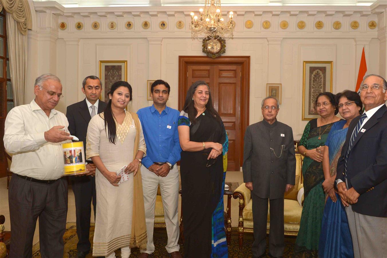 Smt. Ameena Jung, Chairperson along with other from Indian Red Cross Society (National Capital Territory Branch), Delhi pinning to the President of India, Shri Pranab Mukherjee on the occasion of Red Cross Flag Week at Rashtrapati Bhavan on November 02, 2