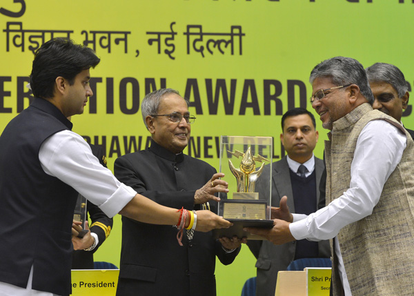 The President of India, Shri Pranab Mukherjee while presenting a Painting Competition Award at Vigyan Bhavan in New Delhi on December 16, 2013 on the occasion of the National Energy Conservation Day. Also seen is the Minister of State for Power (Independe